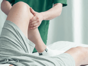rehabilitacja kolana po operacji – fizjoterapeuta pracuje z pacjentem