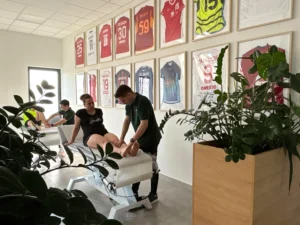 Fizjoterapeuci Kacper Drygajło i Damian Słowiński podczas terapii manualnej pacjentów w sali rehabilitacyjnej JJClinic