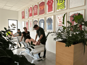 Fizjoterapeuci Kacper Drygajło i Damian Słowiński podczas terapii manualnej pacjentów w sali rehabilitacyjnej JJClinic