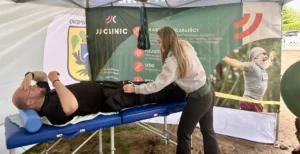 Aleksandra Kaczyńska – fizjoterapeutka JJClinic zakłada sprzęt Normatec do kompresoterapii uczestnikowi biegu