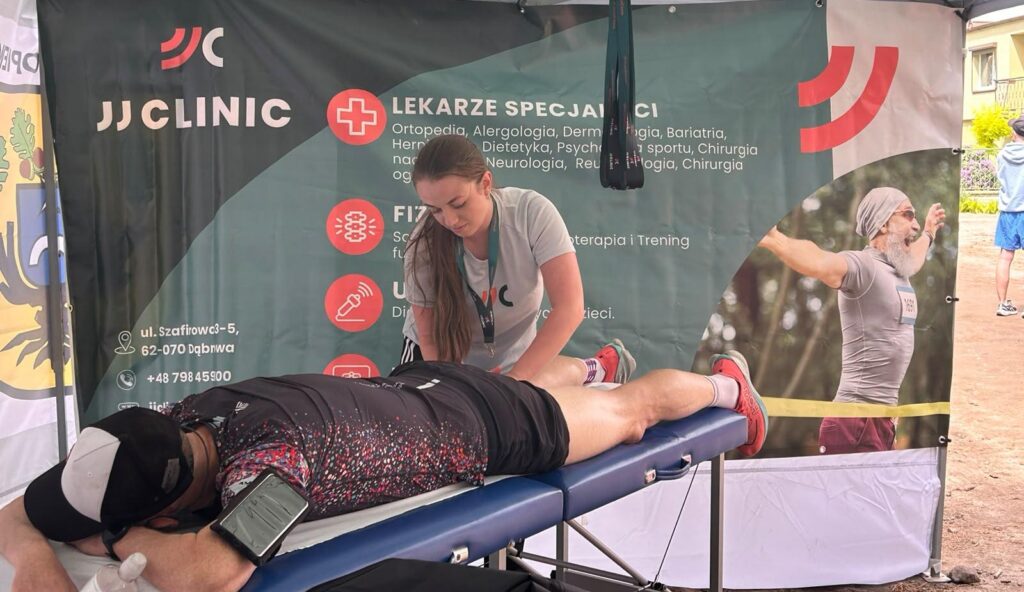 Martyna Forma – technik masażysta JJClinic podczas terapii manualnej dla uczestnika biegu