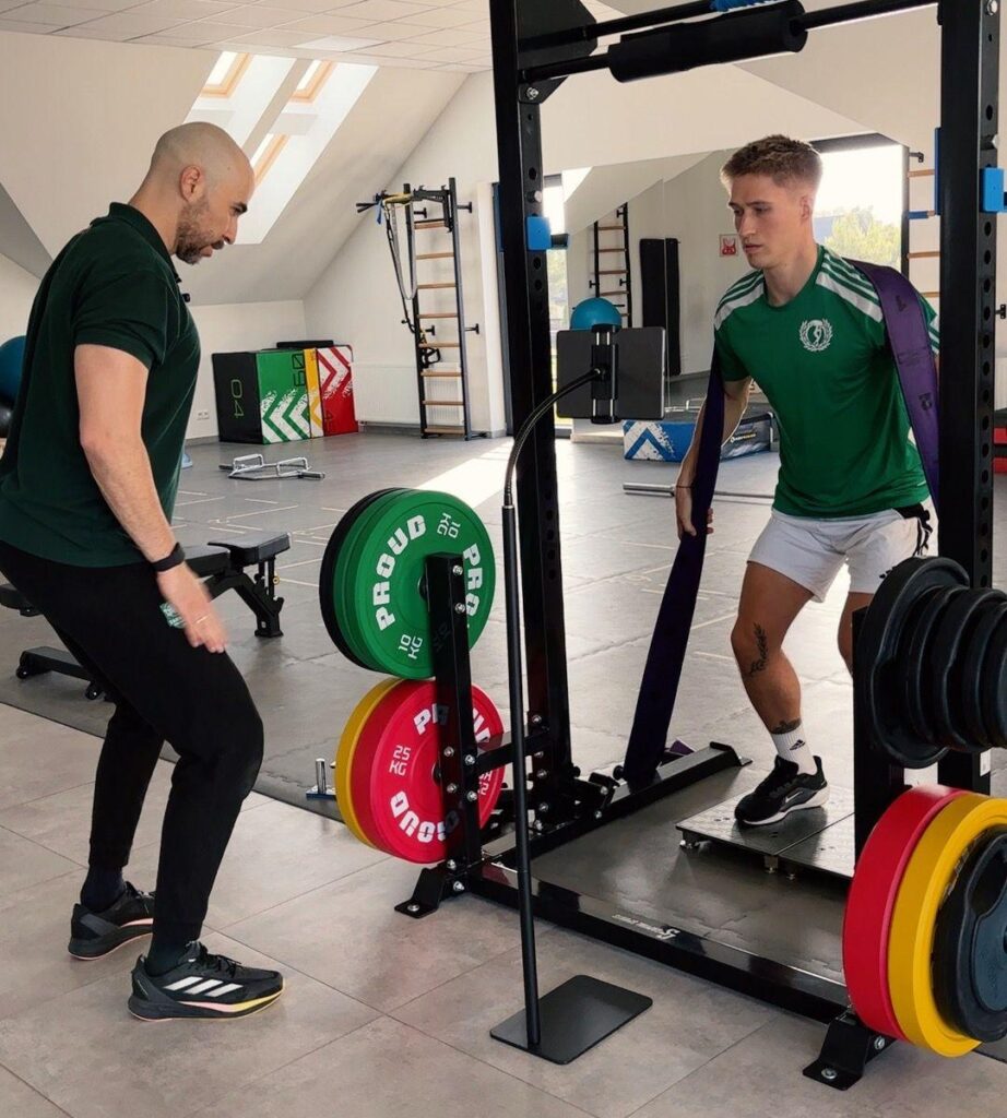 Trener Daniel Barbosa wykonuje z piłkarzem test funkcjonalny na platformach force plates w JJClinic.